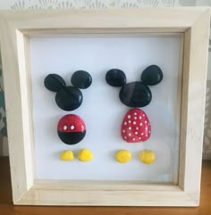 two mickey and minnie mouse heads are in a shadow box with yellow dots on them