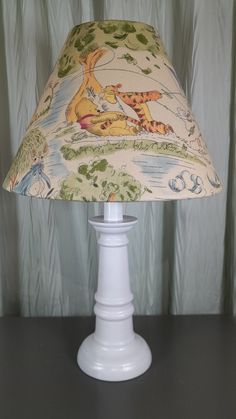 a lamp that is sitting on top of a table with a light shade over it