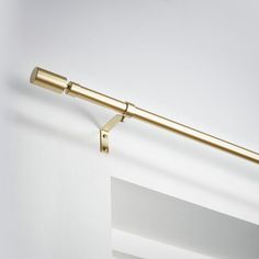 a gold curtain rod is hanging on the wall