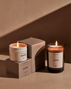 two candles sitting next to each other in front of a box with the word appr on it