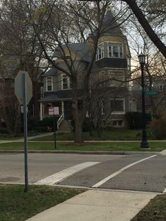 a stop sign at an intersection in front of a large house