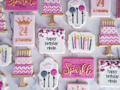 decorated birthday cookies arranged on a table with pink and gold decorations, including candles, forks, spoons and cake