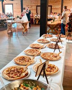 a long table with many pizzas on it