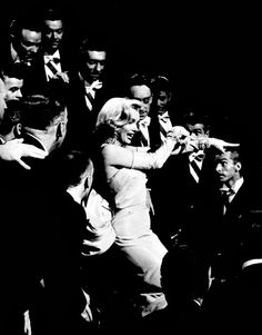 black and white photograph of woman dancing with men