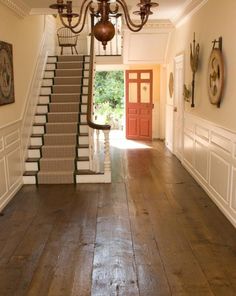 an entryway with stairs and chandelier in the middle, leading to another room