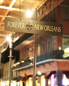 a street sign hanging from the side of a metal pole in front of a building