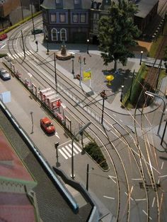 an aerial view of a train station with cars on the tracks and buildings in the background