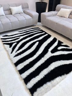 a black and white rug on the floor in a living room with two couches