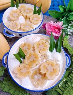 two bowls filled with banana slices and ice cream on top of a table next to bananas