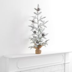 a white christmas tree sitting on top of a mantle