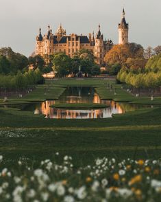 a large castle with a pond in front of it