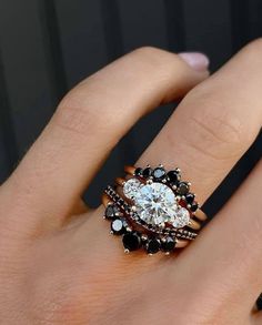 a woman's hand with a ring on it and an engagement ring in the middle