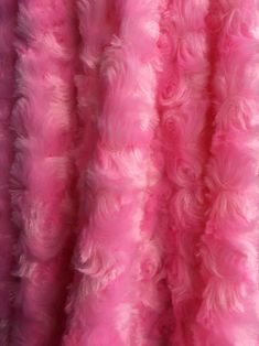 pink and white fur is hanging up in the air with it's long fringes