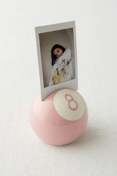 a pink and white ball with a photo on it sitting next to a card holder