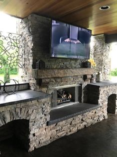 a stone fireplace with a flat screen tv above it