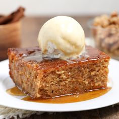 a piece of cake sitting on top of a white plate covered in ice cream and caramel sauce