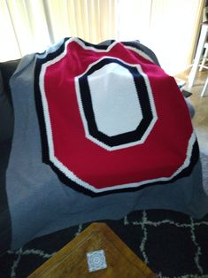 a red and black blanket sitting on top of a couch