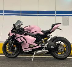 a pink motorcycle parked in front of a building