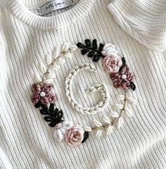 a white sweater with flowers on it