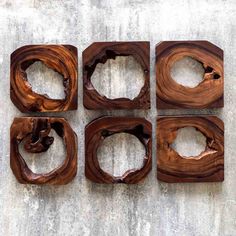 four pieces of wood sitting on top of a cement floor with holes in the middle