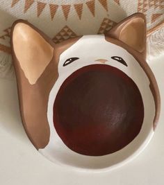 a brown and white plate with a dog's face painted on it