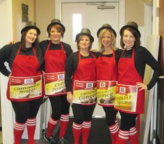 four women in red aprons and black hats are posing for the camera