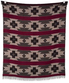 a blanket with black, red and white designs on the front is folded in two rows