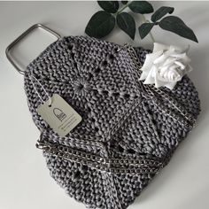 a crocheted purse with a white rose on it and a price tag attached