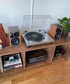 a record player sitting on top of a wooden shelf