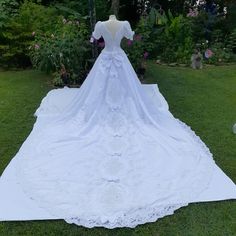 a white wedding dress on display in the grass