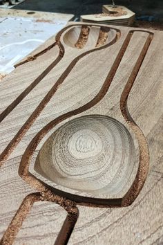 a wooden table that has been carved into some sort of design on it, with two bowls in the middle