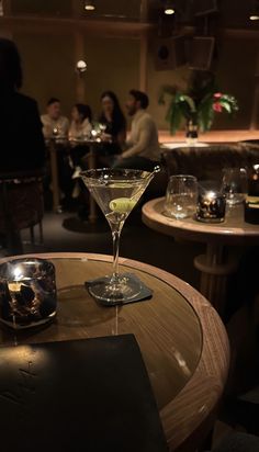 a martini glass sitting on top of a wooden table