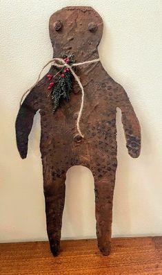 an old fashioned wooden doll hanging on a wall