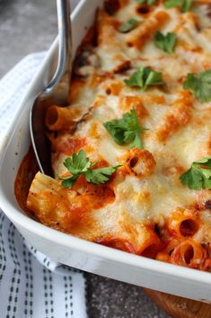 a casserole dish with meat and cheese, garnished with parsley