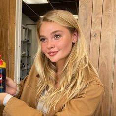 a woman holding up a spray bottle with spiderman on it's side and smiling at the camera