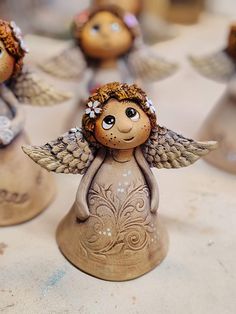 small ceramic angel figurines sitting on top of a table