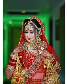 a woman dressed in red and gold is posing for the camera with her hands on her chest