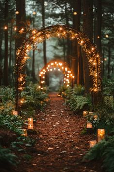 candles are lit up in the middle of a forest path that leads to an archway