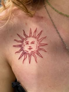 a woman with a sun tattoo on her chest