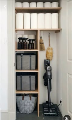 the shelves in this bathroom are filled with toiletries and cleaning supplies, including a vacuum cleaner