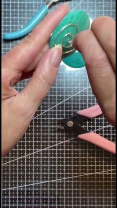 someone using scissors to cut paper on a piece of crafting material with colored crayons