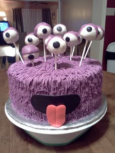 a cake decorated with purple frosting and eyes