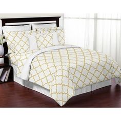 a bed with white and yellow comforters in a room