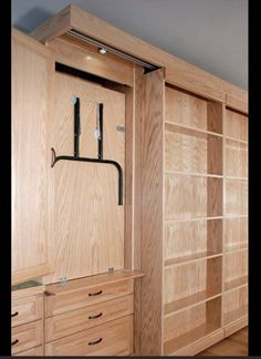 a large wooden closet with sliding doors and drawers on both sides, in an empty room