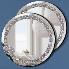 two round mirrors are shown in front of a window