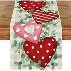 three hearts on a checkered table cloth with green leaves and red polka dotes