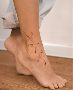 a close up of a person's foot with a flower tattoo on the ankle