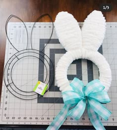 the bunny ears are made out of yarn and tied with a blue ribbon on top of a cutting board