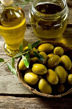 olives in a bowl next to a jar of oil