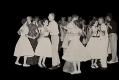 an old black and white photo of people dancing